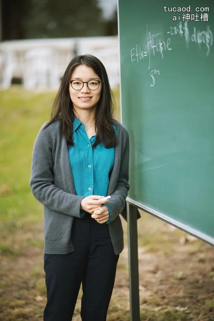 王虹站在黑板前,黑板上写有欧拉公式等数学公式